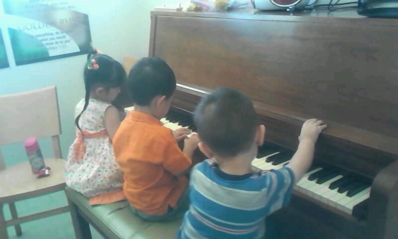 Three kids playing with the piano at church Three kids playing with the piano at church